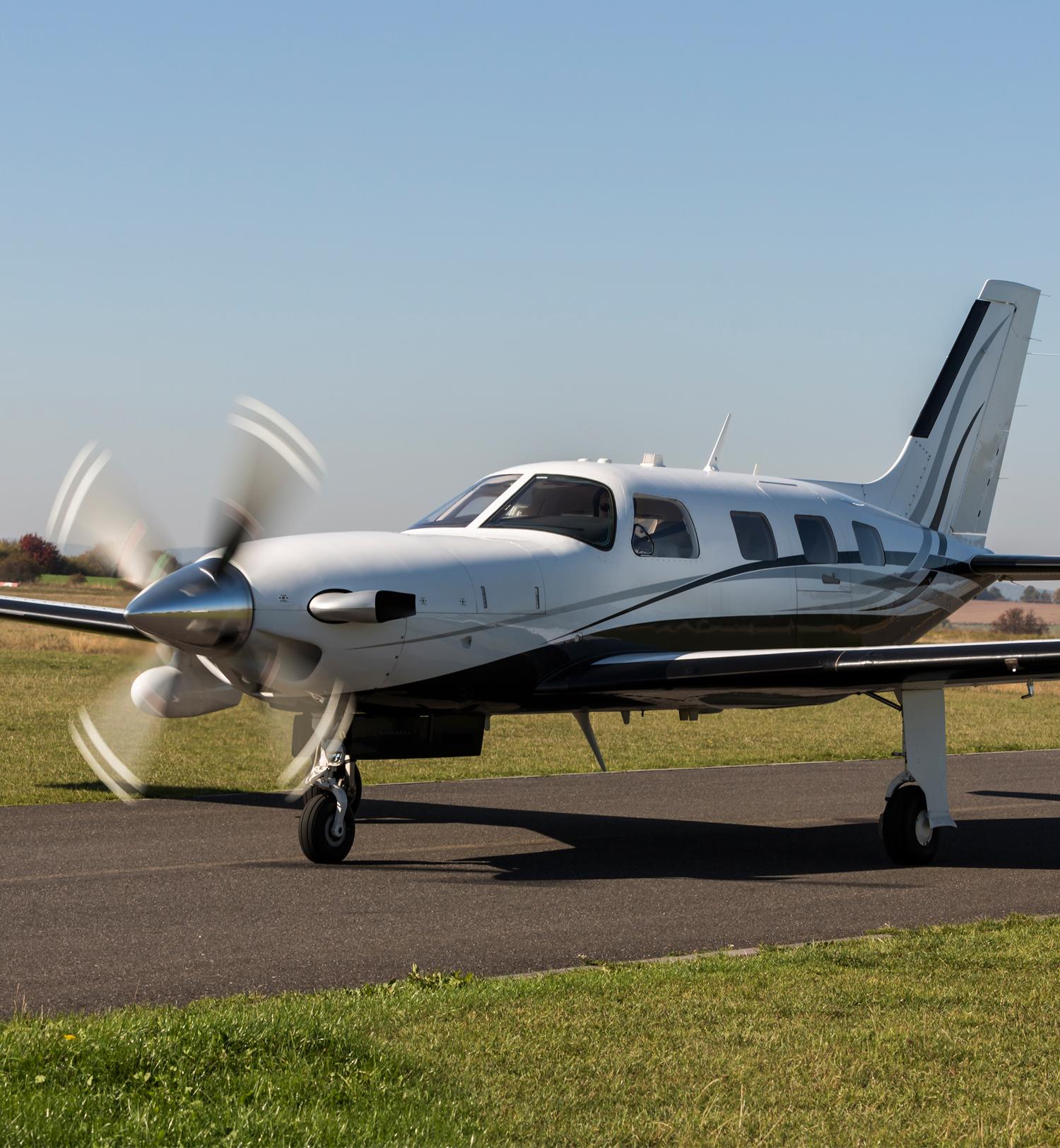 piston aircraft on runway with prop running